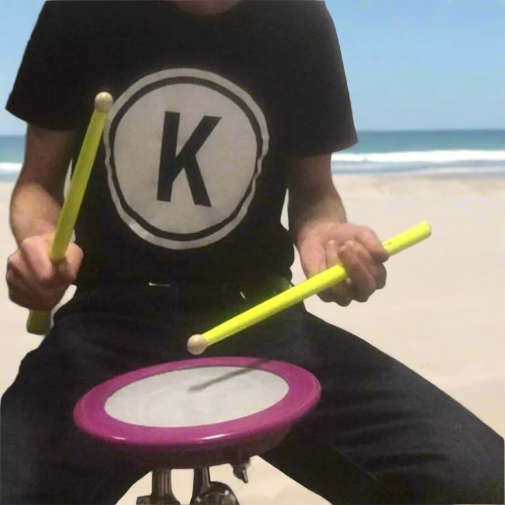 Knaute spielt auf Trommelböckli am Strand